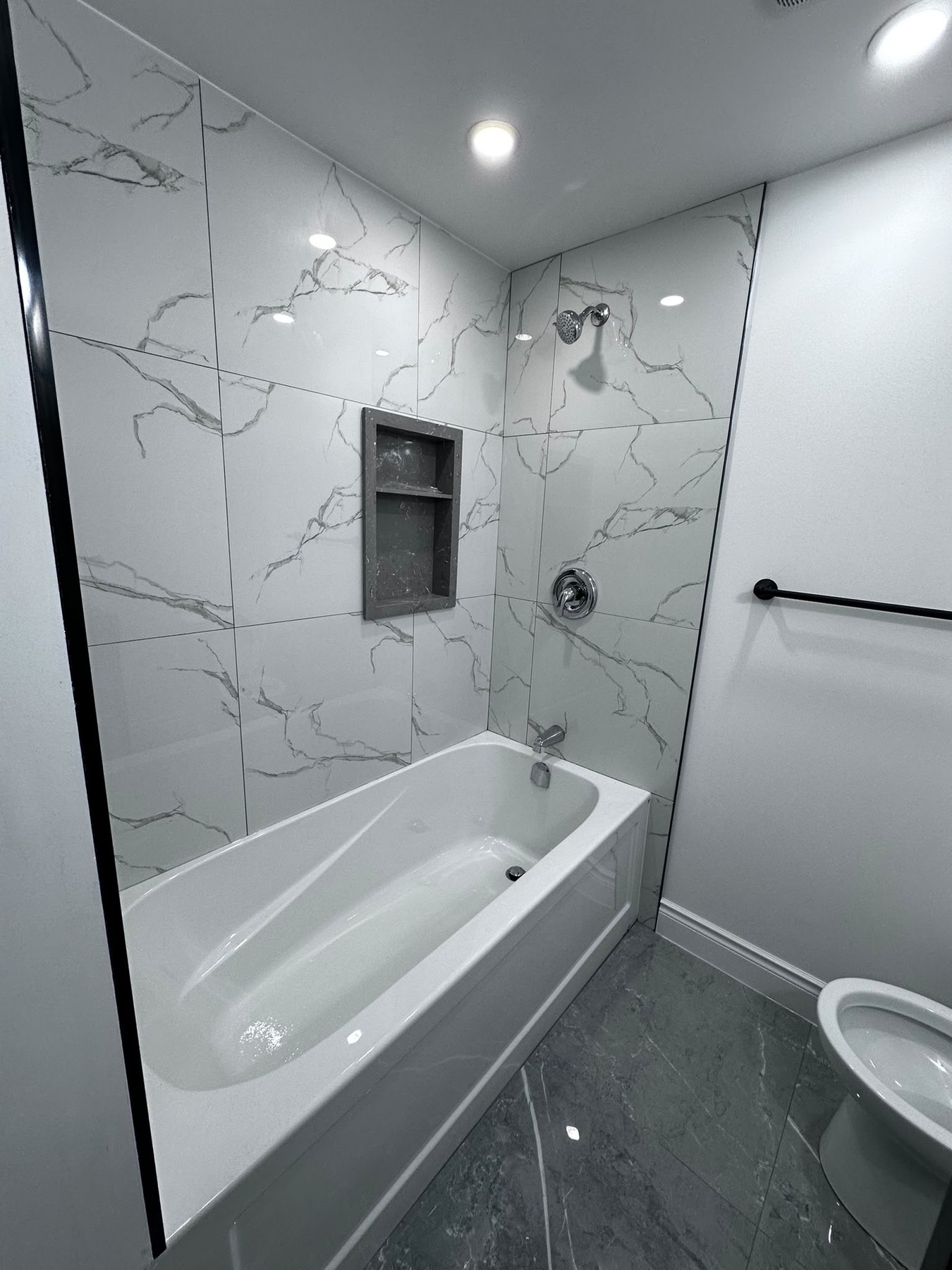 Bathroom renovation with marble wall tiles and bathtub